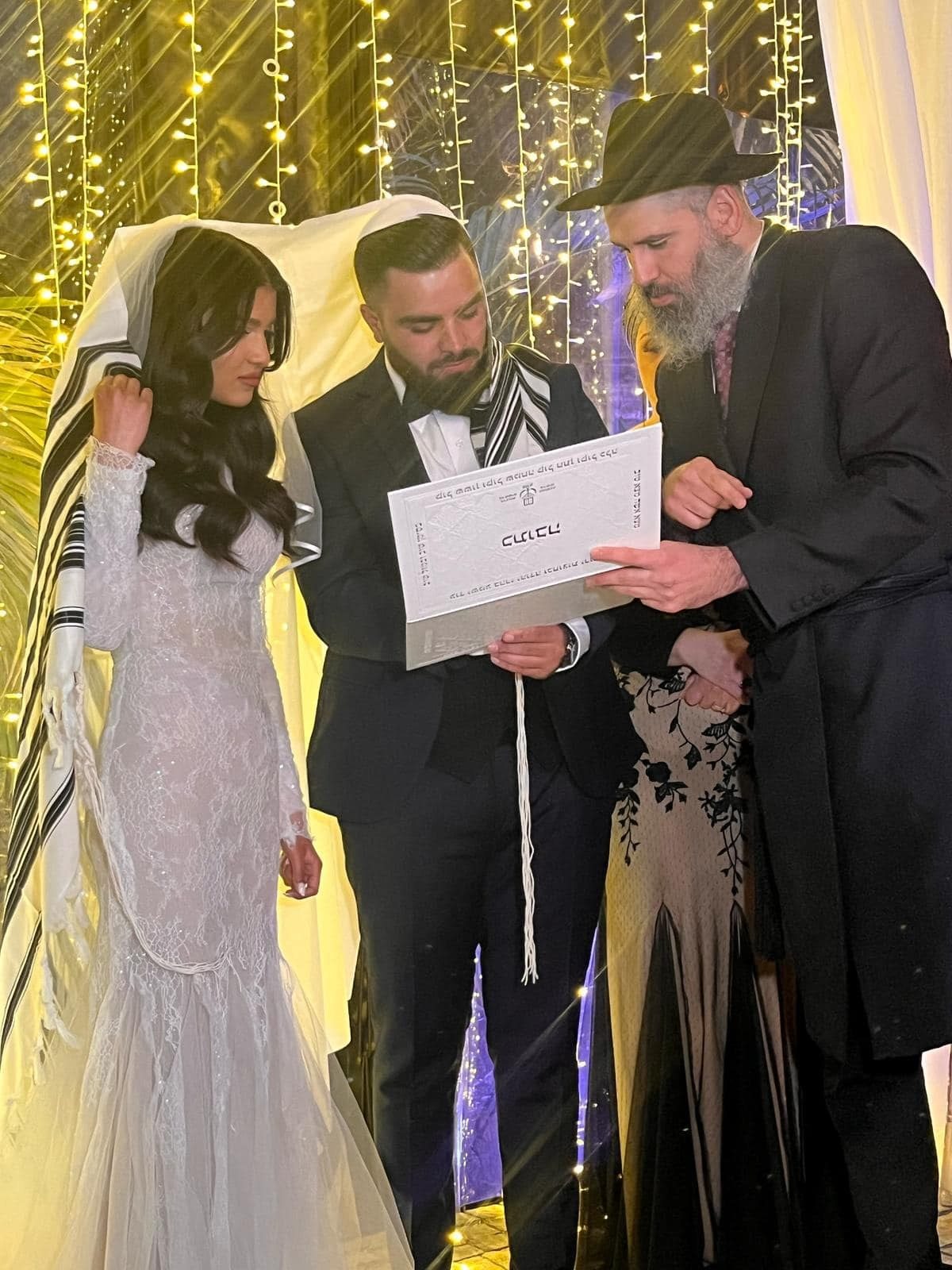 הרב מאור מאיר אוחנה מראה לזוג את הכתובה מתחת לחופה